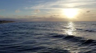 Sersemletici ve güzel bir gün batımı, sakin okyanus suları üzerine parlak altın renkler dökme, rahatlama temaları için ideal