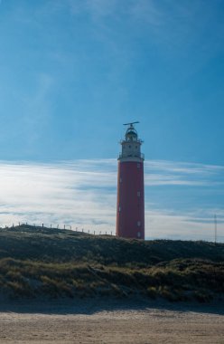 Eierland, De Cocksdorp, Texel, Hollanda, Ekim 28, 2024, Kumlu kumulların arasında görkemli bir deniz feneri vardır.