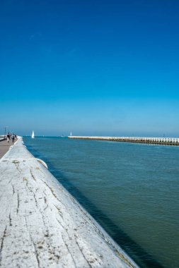 Huzurlu ve huzurlu bir manzara. Güzel bir rıhtım manzarası. Çeşitli tekneler mavi gökyüzünün altında yavaşça süzülüyor.