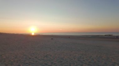 Nefes kesici ve büyüleyici bir günbatımı, sıcak, altın renkleriyle sahili aydınlatıyor.