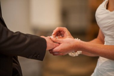 Sevimli bir çift yüzüklerini neşeyle değiş tokuş eder. Güzel bir düğün töreninde.