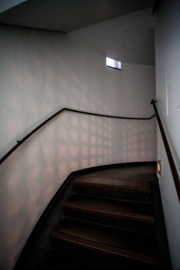 Yumuşak, sanatsal ışık desenleriyle aydınlatılmış güzel kıvrımlı bir merdivenin büyüleyici ve çarpıcı bir görüntüsü.