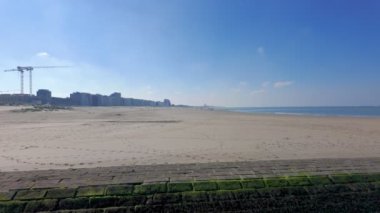 Nieuwpoort, Batı-Flanders, Belçika, 6 Ekim 2024, berrak, berrak mavi gökyüzünün altında geniş, genişleyen kumlu bir sahil manzarası.