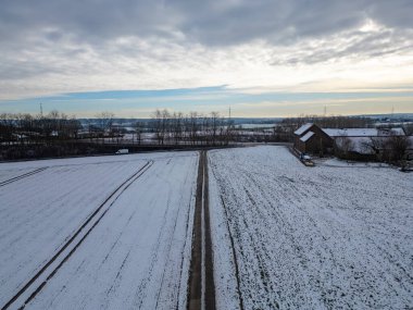 Geniş karlı tarlaların ve büyüleyici bir kır evinin yer aldığı harika huzurlu bir kış manzarası.