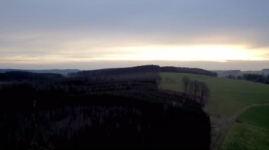 Esmer gökyüzünün altındaki yuvarlanan tepelerin güzel ve huzurlu manzarası, doğal temalı projeler için ideal.