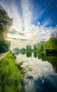Güzel, sakin bir nehir manzarası yemyeşil ve dramatik gökyüzü ile doğanın çarpıcı güzelliğini gözler önüne seriyor.