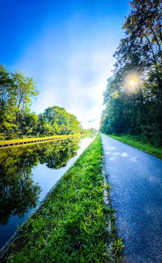 Parlak bir gökyüzü altında doğanın dingin güzelliğini güzel bir şekilde yansıtan şaşırtıcı derecede güzel bir nehir yolu.