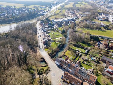 Lier, Antwerp, Belçika, 5 Mart 2025, çarpıcı bir hava görüntüsü canlı bir şekilde nehir boyunca uzanan, yemyeşil alanlar tarafından kucaklanan resimli bir köy yakalıyor.