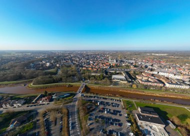 Lier, Antwerp, Belçika, 5 Mart 2025 'te bu hava fotoğrafı yemyeşil ve açık mavi gökyüzüyle çevrili canlı bir kentsel alan yakalar.
