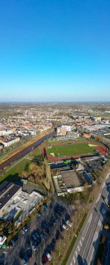 Lier, Antwerp, Belçika, 5 Mart 2025 'te geniş, berrak mavi gökyüzünün altında güzel bir parkın bulunduğu canlı bir şehir manzarası sergiliyor.