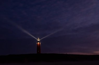 Eierland, De Cocksdorp, Texel, Hollanda, 28 Ekim 2024 büyüleyici bir deniz feneri büyüleyici alacakaranlık gökyüzüne karşı parlak ışığını yayar ve gemileri güvenli bir şekilde limana götürür.