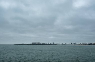 Den Helder, Hollanda, 28 Ekim 2024 bulutlu bir gökyüzünün altında sakin bir kıyı şeridi, doğal ilham için ideal.