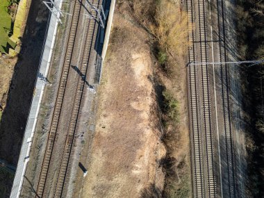 İnsansız hava aracı görüntüsü demiryolu raylarını ve komşu çorak araziyi gösteriyor, altyapıyı ve doğayı ön plana çıkarıyor..