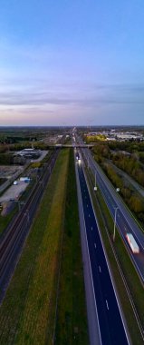 E19 Breda-Antwerp, Brecht, Antwerp, Belçika, 8 Nisan 2025, Bu çarpıcı hava görüntüsü güzel alacakaranlık saatinde yemyeşil otobanın çevresini sarar.