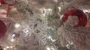 Karmaşık dekore edilmiş bir Noel ağacının, kar tanesi süsü ve sıcak ışıklı bir fotoğrafı.