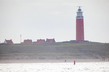Eierland, De Cocksdorp, Texel, Hollanda, Ekim 28, 2024, Bu manzara kumlu kum tepelerinde büyüleyici bir deniz feneri yakalar.
