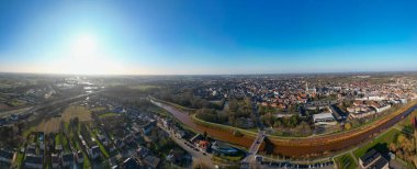 Lier, Antwerp, Belçika, 5 Mart 2025, çarpıcı bir hava manzarası canlı bir şehir alanı sergiliyor, yemyeşil ve tamamen açık mavi bir gökyüzü var.