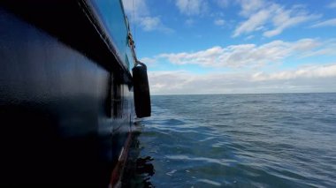 Huzurlu ve sakin bir manzara. Bir tekneden güzel bir okyanus manzarası. Yumuşak bulutları ve sakin suları aydınlatan.