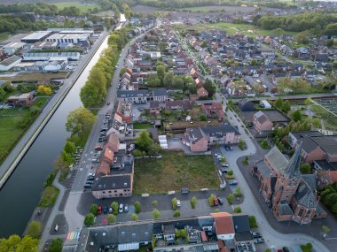 Sint Jozef, Rijkevorsel, Antwerp, Belçika, 27 Nisan 2025, büyüleyici bir hava görüntüsü evlerle, manzaralı nehirlerle ve yemyeşil alanlarla dolu bir banliyö bölgesi sunar.