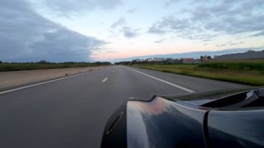 Alacakaranlıktaki pitoresk bir otoyol sahnesi, çarpıcı doğa ve manzara manzaraları arasında pürüzsüz bir yolculuk sergiliyor.
