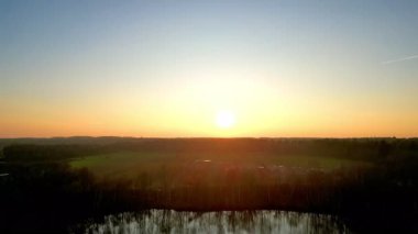 Nefes kesici ve çarpıcı bir gün batımı görüntüsü durgun su yüzeyine yansıyan canlı renkler sergiliyor.