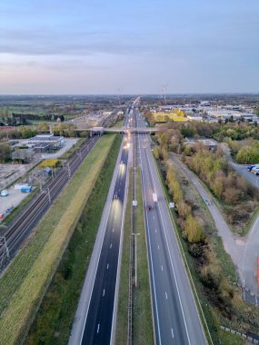 E19 Breda-Antwerp, Brecht, Antwerp, Belçika, 8 Nisan 2025, yemyeşil otobanın havadan görünüşü ve geniş şehir altyapısı nefes kesici.