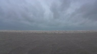 Okyanus dalgalarının bulutlu gökyüzünün altında dalgalanan sakin görüntüsü, barışçıl güzellikleri yakalıyor.