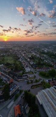 Bergensesteenweg, Sint-Pieters-Leeuw, Brüksel, Belçika, 13 Mayıs 2025, çarpıcı bir günbatımı huzurlu banliyöde sıcak bir ışık yaratarak, buna tanıklık eden herkesi büyüledi.