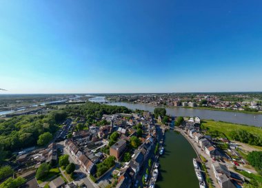 Klein-Willebroek, Willebroek, Antwerp, Belçika, 13 Mayıs 2025. Yeşillik ve açık mavi gökyüzünün yer aldığı muhteşem ve nefes kesici bir deniz manzarası.