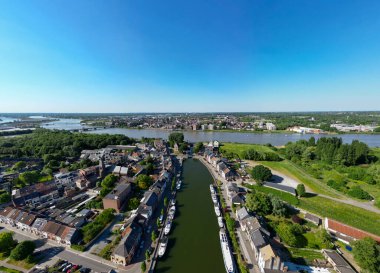 Klein-Willebroek, Willebroek, Antwerp, Belçika, 13 Mayıs 2025, tekneleri, yeşilliği ve açık gökyüzü olan sakin bir kanal şehri, keşif ve rahatlama için ideal.