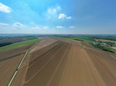 Karmaşık tarla desenleri ve canlı yaz renkleriyle yemyeşil tarlaların havadan görünüşü çarpıcı bir manzara yaratıyor.