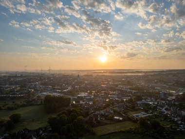 Halle, Vlaams Brabant, Belçika, 13 Mayıs 2025 doğayla güzel bir şekilde çevrili sakin küçük bir kasabayı yavaş yavaş aydınlatan şafağın nefes kesici manzarası.