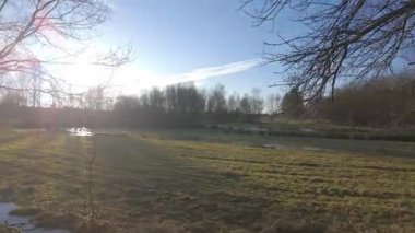 Sabahın erken saatlerinde sakin bir nehir kıyısı sahnesi, etrafındaki huzurlu doğal güzellikleri gözler önüne seriyor.