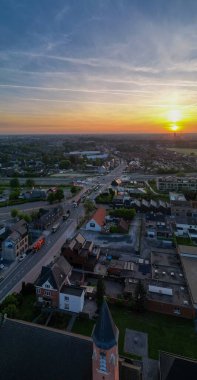 Yalancı, Antwerp, Belçika, 28 Nisan 2025, büyüleyici bir günbatımı canlı şehir manzarasını aydınlatıyor, yolları ve yüksek binaları aydınlatıyor.