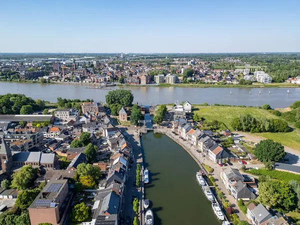 Klein-Willebroek, Willebroek, Antwerp, Belçika, 13 Mayıs 2025, sakin bir su yolu boyunca zarif bir şekilde yerleştirilmiş, nefes kesici bir hava manzarası.