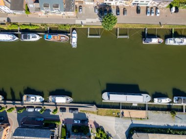 Klein-Willebroek, Willebroek, Antwerp, Belçika, 13 Mayıs 2025, bu çarpıcı hava görüntüsü huzurlu yeşil bir kanala kurulmuş teknelerin sakin bir görüntüsünü yakalıyor.