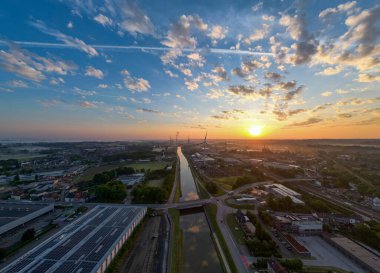 Halle, Vlaams Brabant, Belçika, 13 Mayıs 2025, nefes kesici bir gün batımı manzarası sergilenen sakin bir su yolu ve çarpıcı bir şehir manzarası.