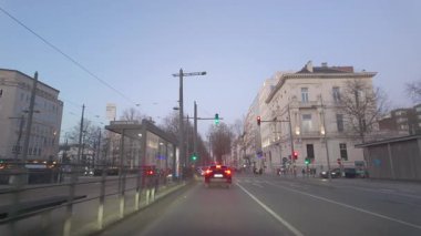 Antwerp, Antwerp, Belçika, 6 Nisan 2025, trafik ışıkları, otobüs durakları ve alacakaranlıktaki tarihi binaların kesiştiği yer..