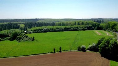Sersemletici hava görüntüleri, kırsal kesimin canlı tarlalarını ve sakin ormanlarını zekice sergiliyor.