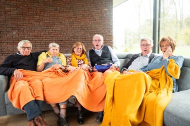 Bu canlı görüntü, bir grup son sınıf öğrencisinin bir kanepede oturup sürükleyici bir televizyon programı izlerken birlikte tepki verdiklerini gösteriyor. İfadeleri şaşkınlık, endişe ve...
