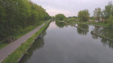 Ağaçlarla çevrili bir kanal boyunca seyahat eden hava görüntüleri. Yüksek kalite 4k görüntü