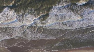 Büyüleyici bir kuş bakışı zarif okyanus dalgalarını kumlu kumsalla buluşurken gösteriyor.