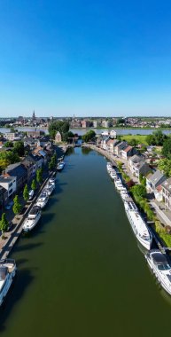 Klein-Willebroek, Willebroek, Antwerp, Belçika, 13 Mayıs 2025, nefes kesen bir hava manzarası büyüleyici evlerle çevrili ve her yerde gelişen yeşil bir kanalı gözler önüne seriyor.