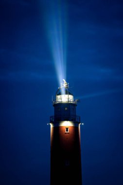 Eierland, De Cocksdorp, Texel, Hollanda, 28 Ekim 2024, görkemli ve çarpıcı bir deniz feneri, parlak ışınını gecenin karanlığına fırlatarak, gemilere sağ salim evlerine dönmeleri için rehberlik ediyor.