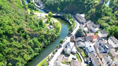Esch-sur-Sure, Wiltz, Grand-Duche de Lüksemburg, 10 Ağustos 2025, Sersemletici hava fotoğrafçılığı, yemyeşil ve büyüleyici binalarla zenginleştirilmiş huzurlu bir nehir kıvrımını güzel bir şekilde yakalar.