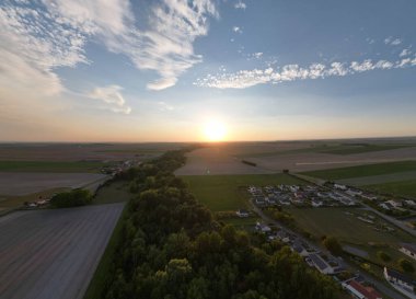 Bergnicourt, Rethel, Ardennes, Grand-Est, France, August, 28th, 2025,A stunning aerial view of a vibrant sunset illuminating a serene landscape with lush fields and a quaint village
