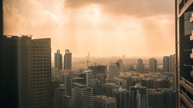 Günbatımında arka planda bulutlu gökyüzü olan modern uzun konut ve şirket binaları, Dubai, BAE