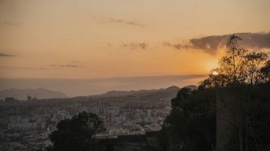 Malaga 'nın tarihi Katedrali şehir manzarası ve siluet dağları arasında gün batımında Malaga, Endülüs, İspanya' da gökyüzüne karşı