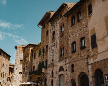 Güneşli bir günde İtalya 'da mavi gökyüzünün altında tuğlalı duvarları olan eski konut binalarının düşük açılı görüntüsü