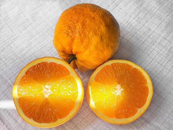 Ganze Früchte Und Geschnittene Saftige Orange Vom Sonnenlicht Erhellt Auf — Stockfoto